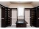 Custom walk-in closet with dark wood shelving and a granite-topped island at 1837 Haven Park Se Cir, Smyrna, GA 30080