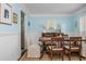 Bright dining room with blue walls, wood floors, a rustic dining table, and natural light at 2038 Drogheda Ln, Marietta, GA 30066