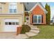 Welcoming front entrance with a brick accent, green lawn and manicured landscaping at 2038 Drogheda Ln, Marietta, GA 30066