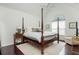 A view of the main bedroom featuring vaulted ceilings, fan, four-poster bed, and dark-stained hardwood floors at 2038 Drogheda Ln, Marietta, GA 30066