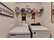 Bright laundry room featuring a washer, dryer, storage shelf, and wall decor at 2730 Henderson Chase Ct, Tucker, GA 30084