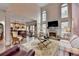 Open-concept living room with hardwood floors, fireplace, kitchen view, and abundant natural light at 2730 Henderson Chase Ct, Tucker, GA 30084