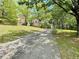 Charming single-Gathering home with a long driveway and lush green lawn, surrounded by mature trees at 610 Coolsprings Ln, Woodstock, GA 30188