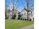 Charming two-story home with gray stucco siding, a landscaped lawn, and mature trees in a desirable neighborhood at 610 Coolsprings Ln, Woodstock, GA 30188