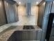 Modern kitchen with stainless steel hood, granite countertops, and dark wood cabinets at 610 Coolsprings Ln, Woodstock, GA 30188