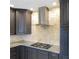 Modern kitchen with stainless steel hood, granite countertops, and dark wood cabinets at 610 Coolsprings Ln, Woodstock, GA 30188