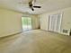 Large living room with neutral carpet, ceiling fan, and sliding glass doors to a backyard patio at 610 Coolsprings Ln, Woodstock, GA 30188