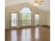 Bright living room featuring vaulted ceilings, hardwood floors, and a large arched window with backyard views at 610 Coolsprings Ln, Woodstock, GA 30188