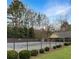 Community pool featuring a fence for safety, surrounded by lush greenery and trees at 610 Coolsprings Ln, Woodstock, GA 30188