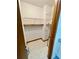 A walk-in closet with vinyl floors, white shelving, and a partial mirror at 610 Coolsprings Ln, Woodstock, GA 30188