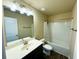 Bathroom features a vanity with a large mirror, modern lighting fixture, and a shower-tub combination with a white shower curtain at 11978 Quail Rd, Hampton, GA 30228