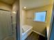 Bathroom features shower, soaking tub, and frosted window for privacy at 11978 Quail Rd, Hampton, GA 30228