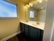 Bathroom featuring a double sink vanity with black cabinets and a large mirror at 11978 Quail Rd, Hampton, GA 30228