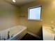 Bathroom with a white soaking tub, window, and vanity at 11978 Quail Rd, Hampton, GA 30228