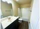 Well-lit bathroom features a vanity with a large mirror and a shower-tub combination with a white shower curtain at 11978 Quail Rd, Hampton, GA 30228