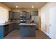 Modern kitchen with gray cabinets, stainless steel appliances, and granite countertops offers stylish functionality at 11978 Quail Rd, Hampton, GA 30228