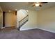Open living room features a ceiling fan and staircase with carpeted steps and wooden railing at 11978 Quail Rd, Hampton, GA 30228