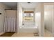 Bright bathroom featuring a soaking tub under a window with natural light and neutral finishes at 4210 Hamilton Walk Dr, Buford, GA 30519