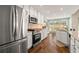Bright kitchen features stainless steel appliances, white cabinetry, and granite countertops with a view to the backyard at 4210 Hamilton Walk Dr, Buford, GA 30519