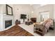 Inviting living room featuring a fireplace, hardwood floors, and comfortable seating area at 4210 Hamilton Walk Dr, Buford, GA 30519