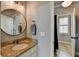 Well-lit bathroom features granite countertops, a round mirror, and neutral wall color at 5340 Cole Creek Ln, Cumming, GA 30040