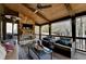 Relaxing covered patio with a stone fireplace, ceiling fan, and plush seating area overlooking the backyard at 5340 Cole Creek Ln, Cumming, GA 30040