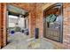 Covered front porch with stone flooring, brick columns, pendant lighting, and outdoor seating at 5340 Cole Creek Ln, Cumming, GA 30040