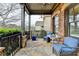 Cozy covered porch with wicker seating, glass table, stone floor, and a view of the neighborhood at 5340 Cole Creek Ln, Cumming, GA 30040