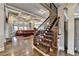 Elegant living room features hardwood floors, coffered ceilings, a staircase, and large windows with natural light at 5340 Cole Creek Ln, Cumming, GA 30040