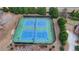 Aerial shot of the tennis courts, showcasing a recreational amenity for residents, surrounded by verdant trees and manicured landscaping at 5340 Cole Creek Ln, Cumming, GA 30040