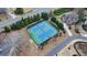 A high angle view of outdoor tennis courts, surrounded by lush trees and manicured landscaping, provide a premier athletic opportunity at 5340 Cole Creek Ln, Cumming, GA 30040