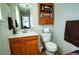 This bathroom features a wood vanity, toilet, mirror, and wood cabinet at 885 Green Valley Dr Nw, Conyers, GA 30012