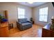 Bedroom with hardwood floors and a comfortable gray daybed next to a dresser at 885 Green Valley Dr Nw, Conyers, GA 30012