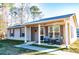 Adorable one-story home boasting a cozy porch with comfortable seating and neat landscaping at 885 Green Valley Dr Nw, Conyers, GA 30012