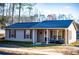 Inviting single-story house with covered porch featuring cozy seating and neat landscaping at 885 Green Valley Dr Nw, Conyers, GA 30012