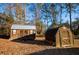 Two wooden storage sheds with a metal roof in the home's backyard at 885 Green Valley Dr Nw, Conyers, GA 30012