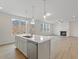 Open-concept kitchen featuring a central island, stainless steel appliances, and views into the cozy living room at 891 Pine Way, Dallas, GA 30157