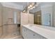 Accessible bathroom with frameless glass shower, white cabinets, and neutral tiling at 2110 Se Murren Se Dr, Smyrna, GA 30080