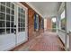 Inviting front porch showcasing brick flooring, white columns, and shutter details at 2110 Se Murren Se Dr, Smyrna, GA 30080