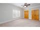 Bedroom with a ceiling fan, light walls, carpet floors, and a large window at 281 Chilhoe Dr, Canton, GA 30115