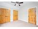 Bedroom featuring a ceiling fan and multiple knotty pine doors at 281 Chilhoe Dr, Canton, GA 30115