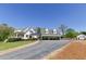 Beautiful white farmhouse exterior with covered parking, long driveway, and lovely landscaping at 281 Chilhoe Dr, Canton, GA 30115
