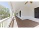 View of a long covered front porch with a wood ceiling and dark shutters at 281 Chilhoe Dr, Canton, GA 30115