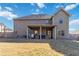 View of the home's back exterior, including a covered patio and spacious, fenced yard at 3823 Dragon Fly Ln, Loganville, GA 30052
