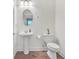 This bathroom features a pedestal sink, wood look flooring, and modern fixtures at 498 Townsend St, Grayson, GA 30017