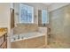 Well-lit bathroom with a walk-in shower and soaking tub at 498 Townsend St, Grayson, GA 30017