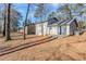 Backyard of home featuring a concrete patio and mature trees in the background, and gray siding at 1908 Sailcloth St, Lithonia, GA 30058