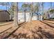 Back of house with patio and trees, featuring gray siding, and is set on a lot with mature trees at 1908 Sailcloth St, Lithonia, GA 30058