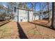 Gray home's backyard with a concrete patio surrounded by mature trees and a spacious lawn at 1908 Sailcloth St, Lithonia, GA 30058