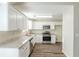 Bright kitchen featuring granite countertops, stainless steel appliances, and white cabinetry at 1908 Sailcloth St, Lithonia, GA 30058